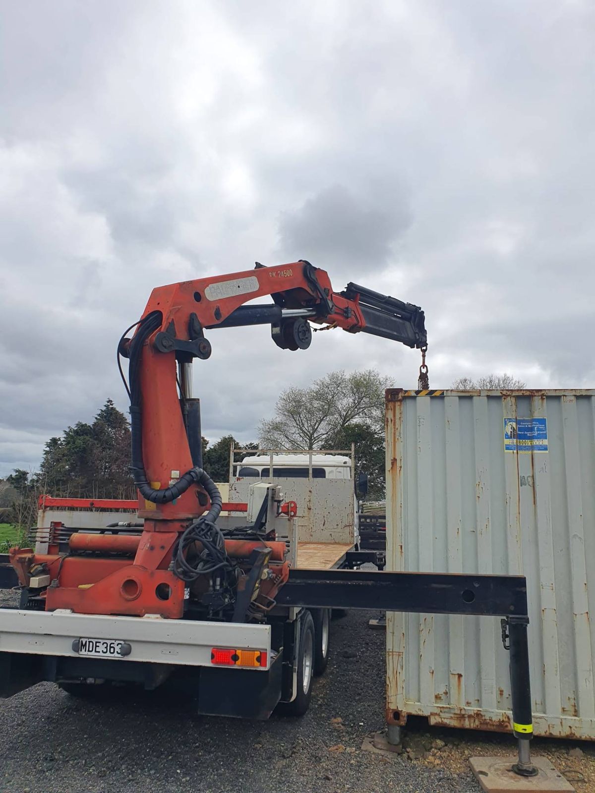 Rear view of the crane truck with the Palfinger crane lifting at a container